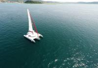 bijeli trimaran na plavom moru sa sunčevim odsjajem